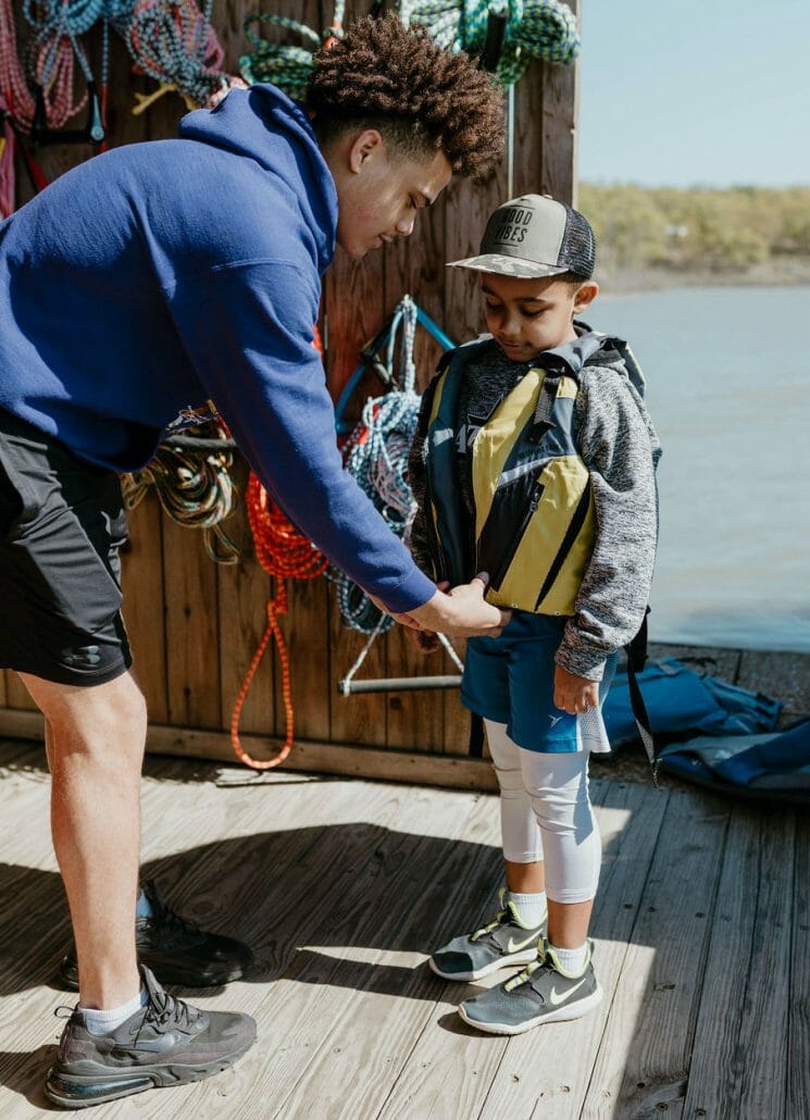 Boat Club helping kid with lifejacket